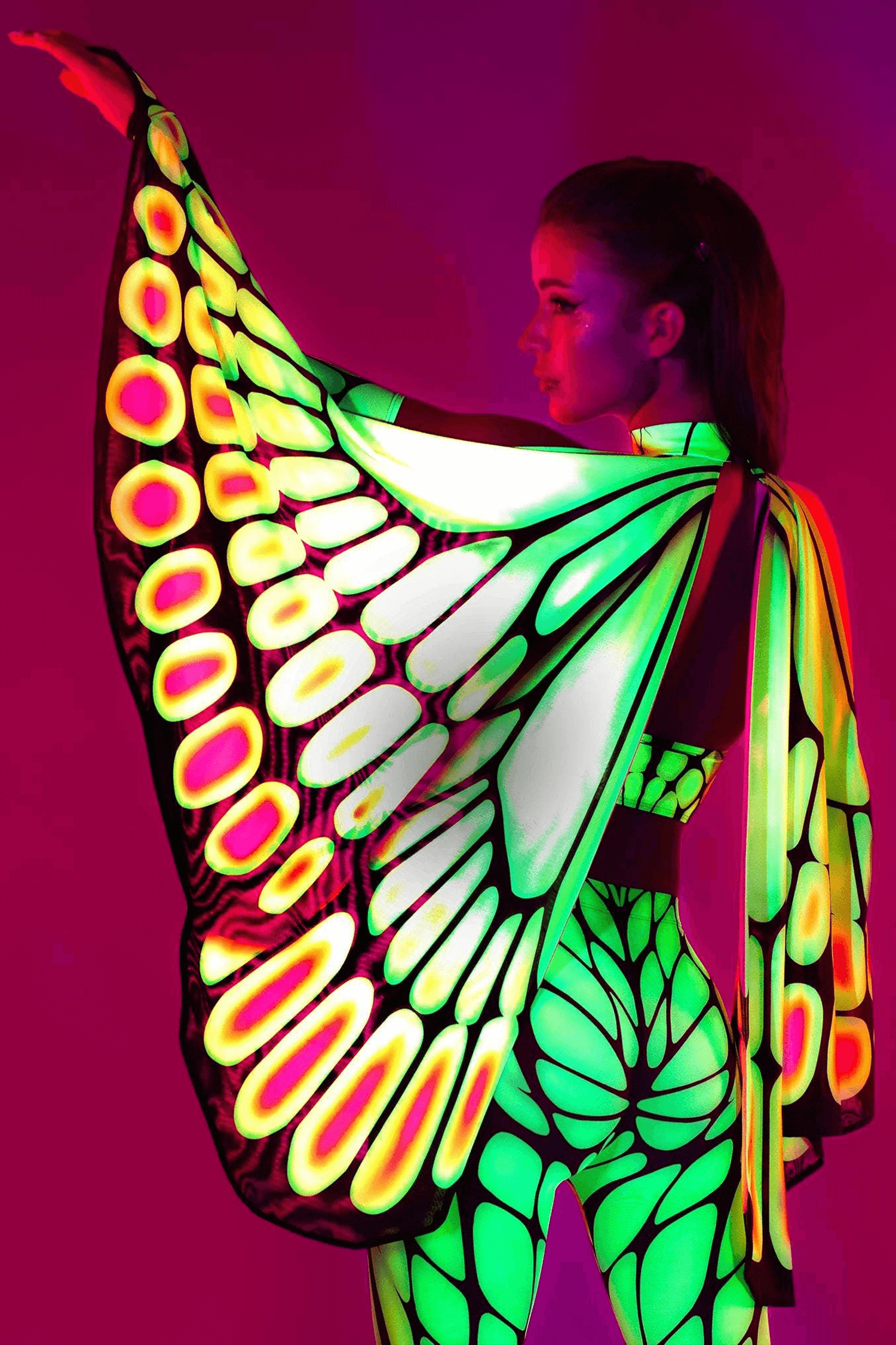 Woman wearing UV-reactive butterfly wings for a rave or festival