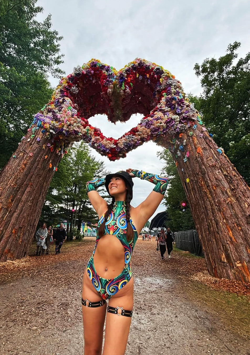 woman with a cut-out bodysuit walks in the Electric Forest festival area
