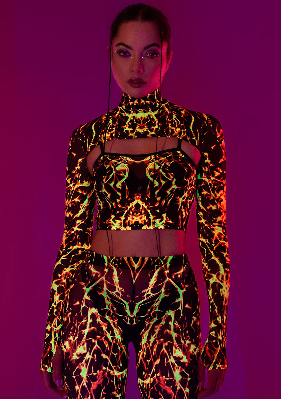 a girl wearing glow-in-the-dark neon uv reflecting leggings and sleeved top with lava, fire pattern