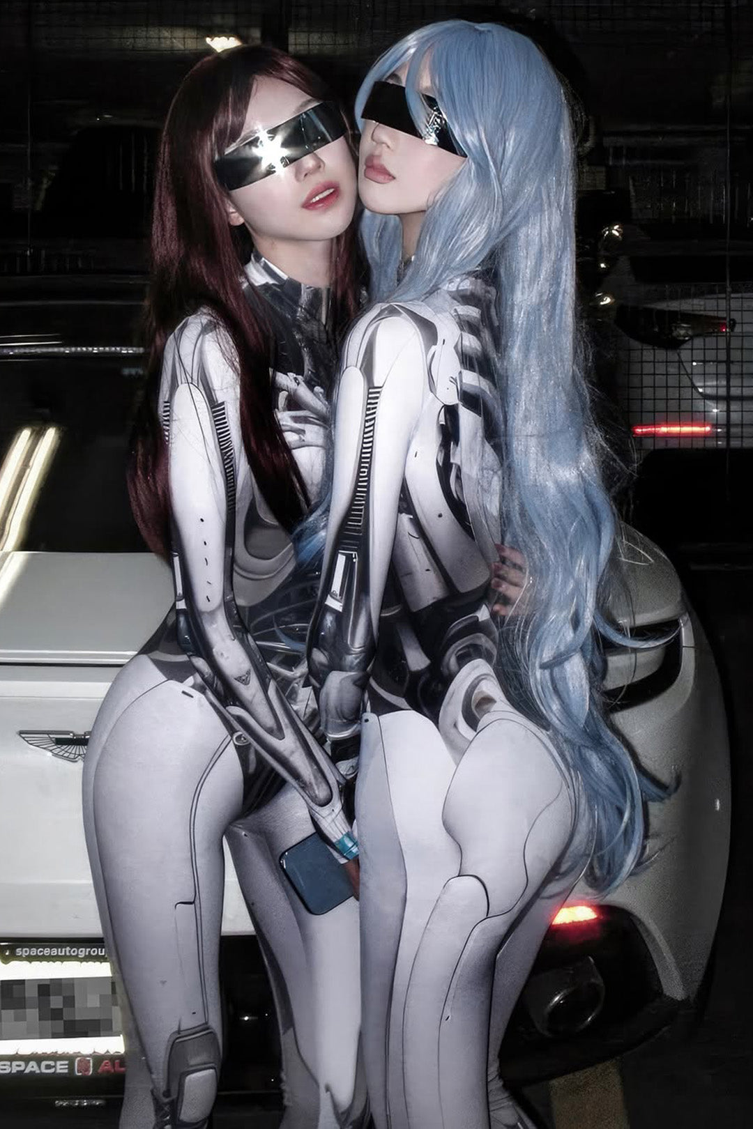 two women in sleek and futuristic android cosplay costumes in black and white
