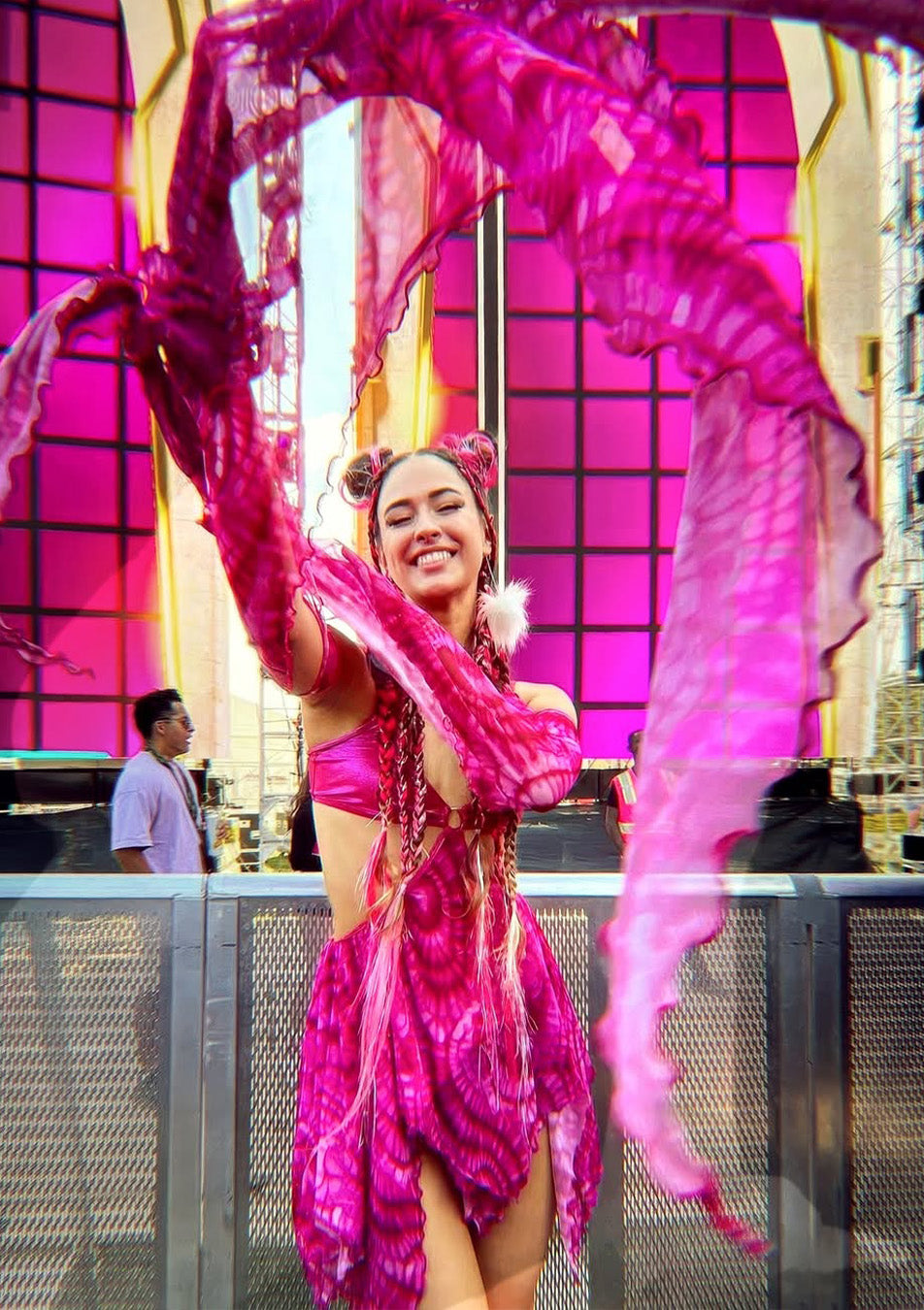 woman wearing an asymmetrical pink dress at an outdoor rave event