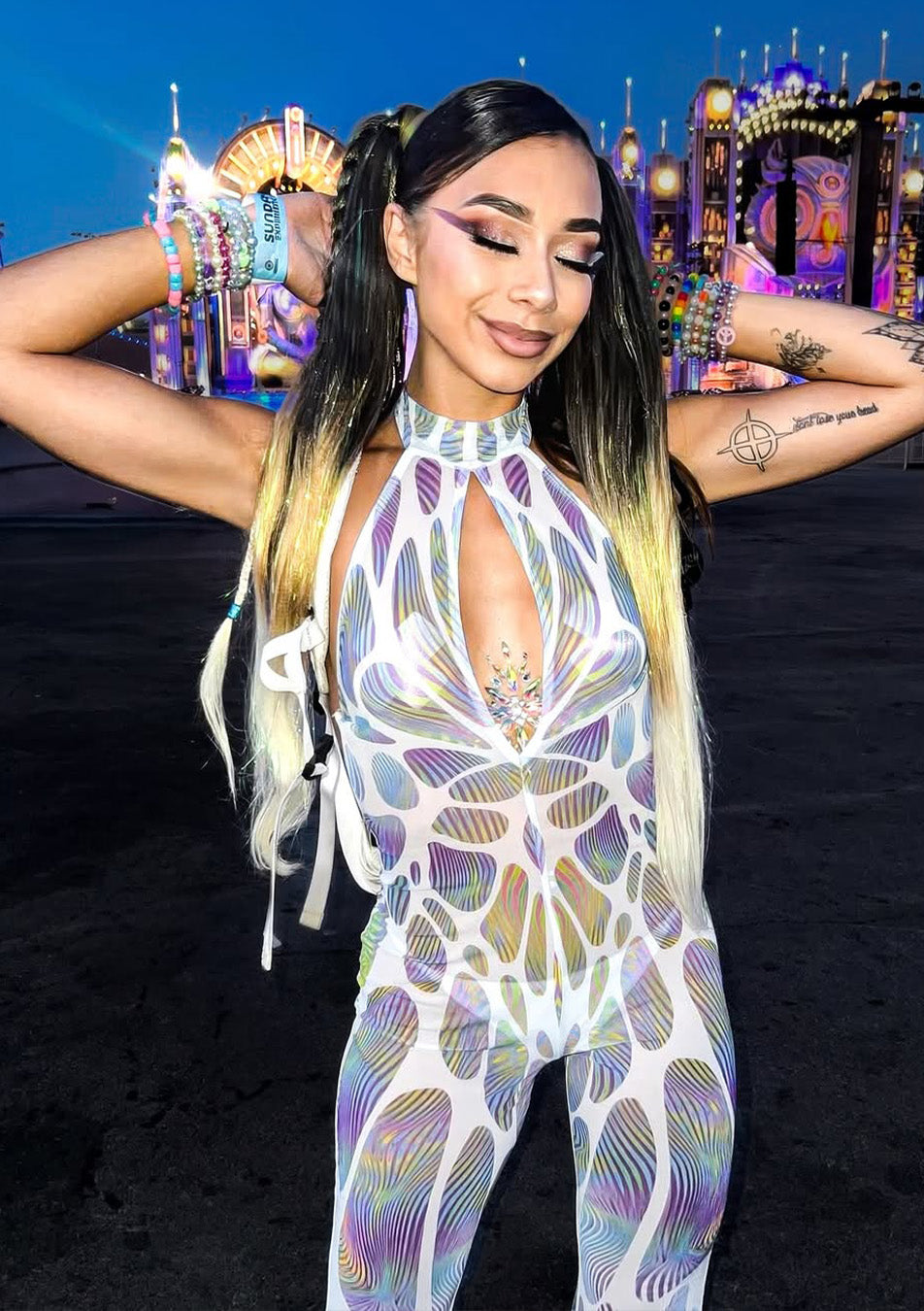 person wearing a printed mesh halter romper at a rave in the evening