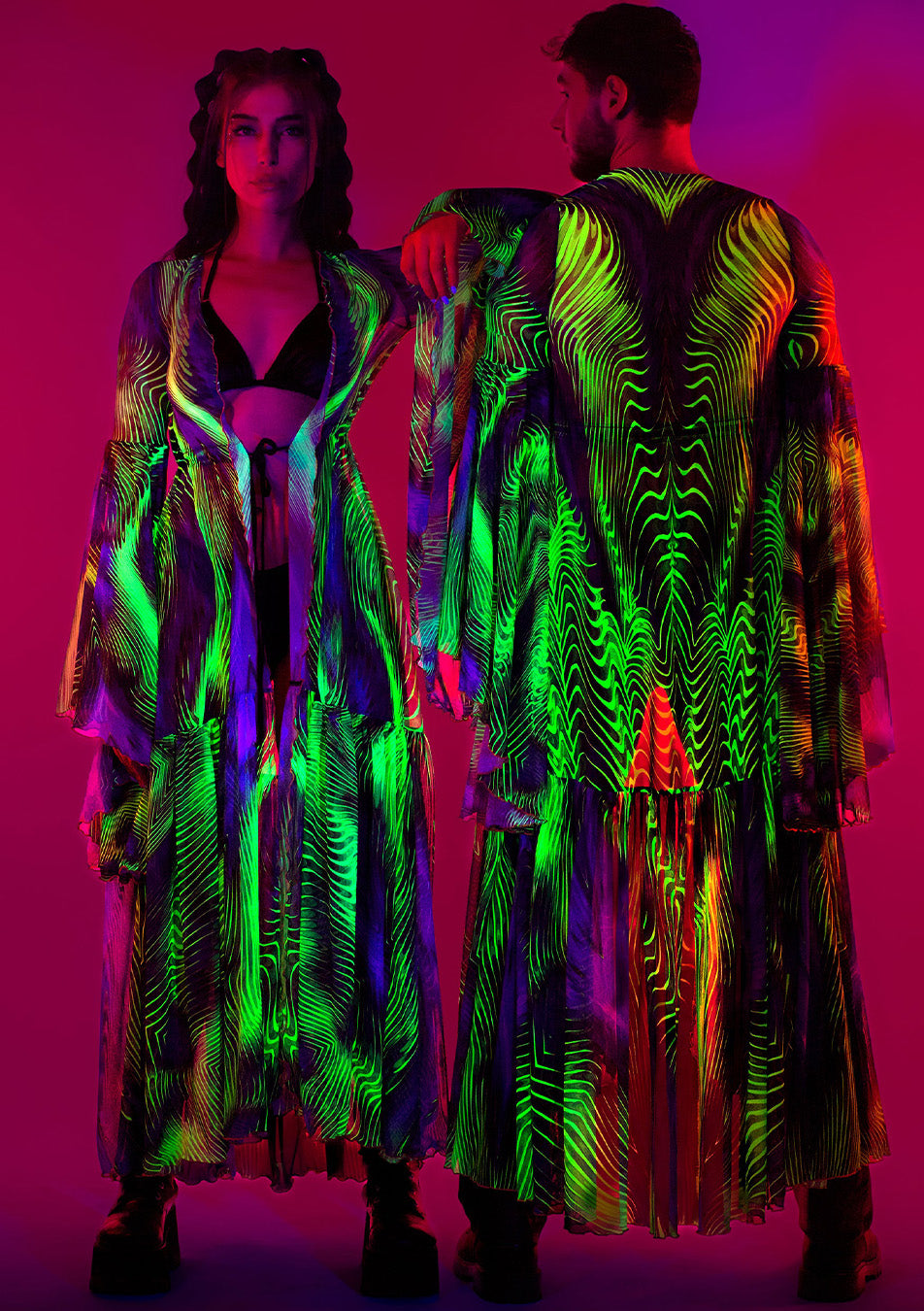 couple wearing matching neon dusters with UV-reactive features 