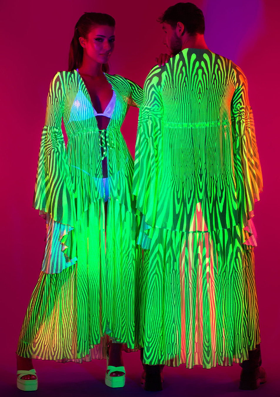 couple wearing matching neon dusters with UV-reactive features 
