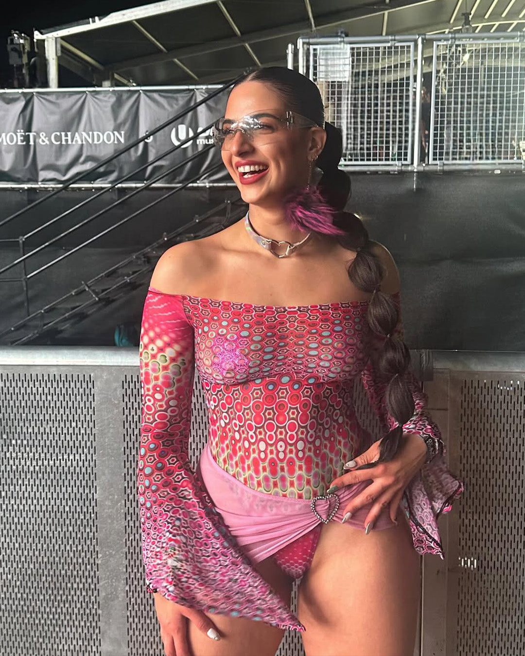 woman wearing a pink mesh bodysuit with bell sleeves for a festival