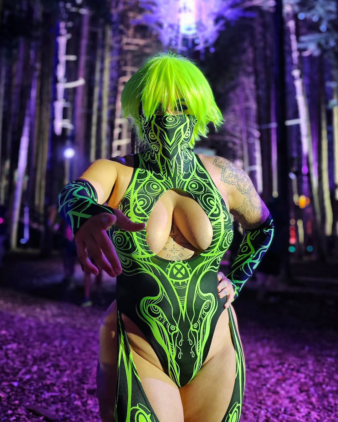 Woman in a green cut-out catsuit roaming between the seven stages of Electric Forest fest