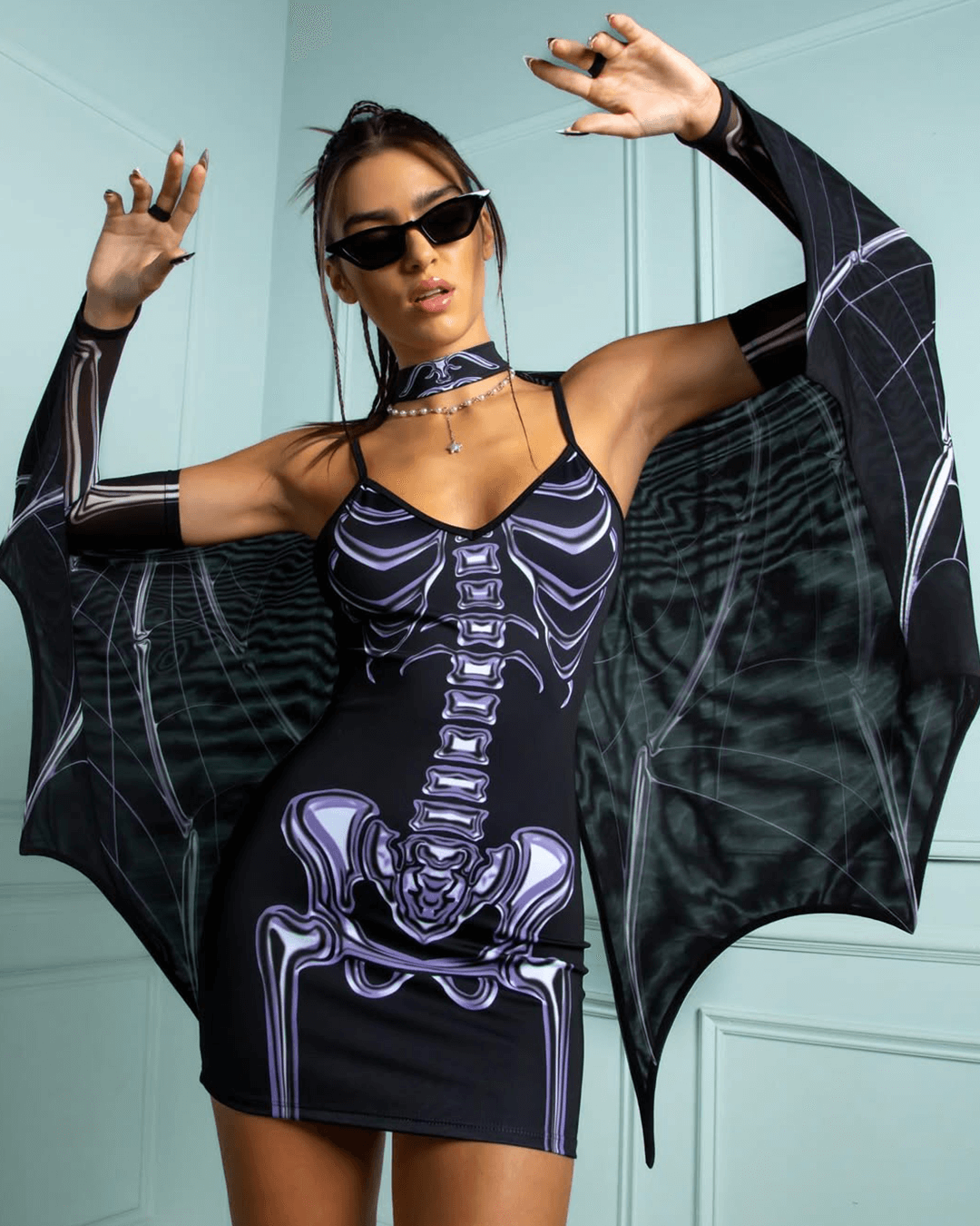 woman in a skeleton dress with bat wings dressing up for a rave festival