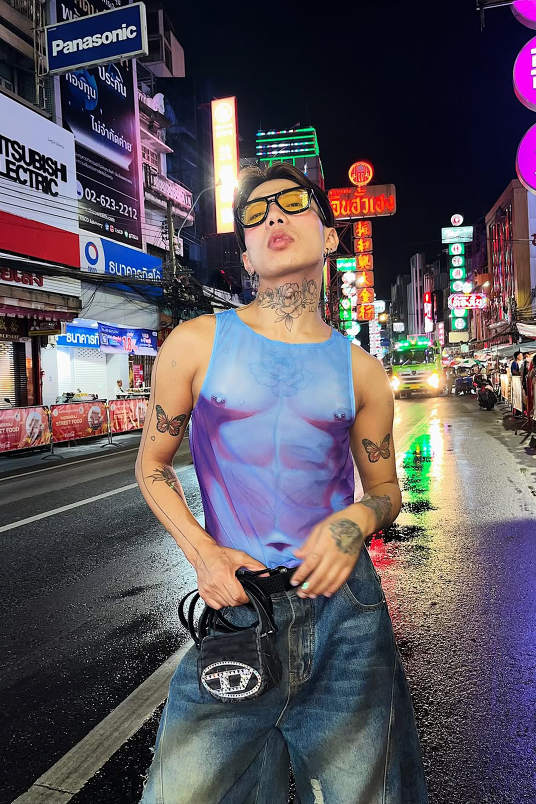 a man on the street wearing purple mesh top